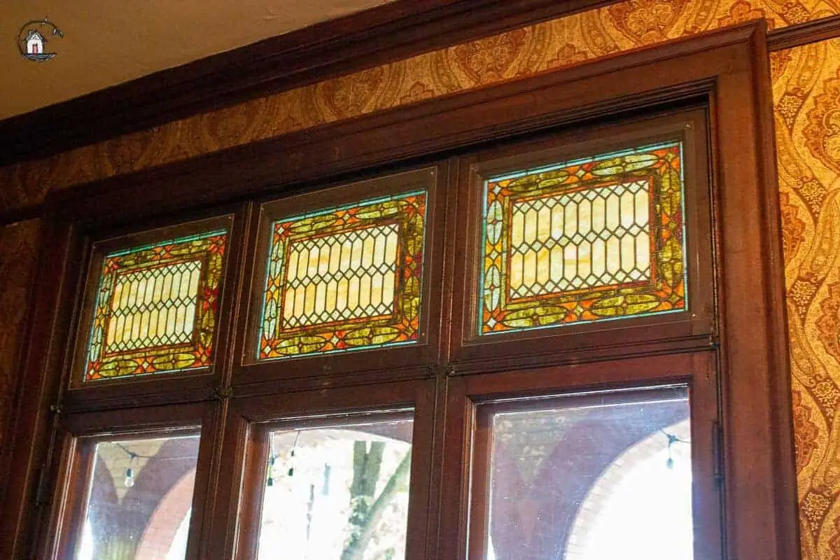 Photo of three stained glass windows in the Library of the Vrooman Mansion. 