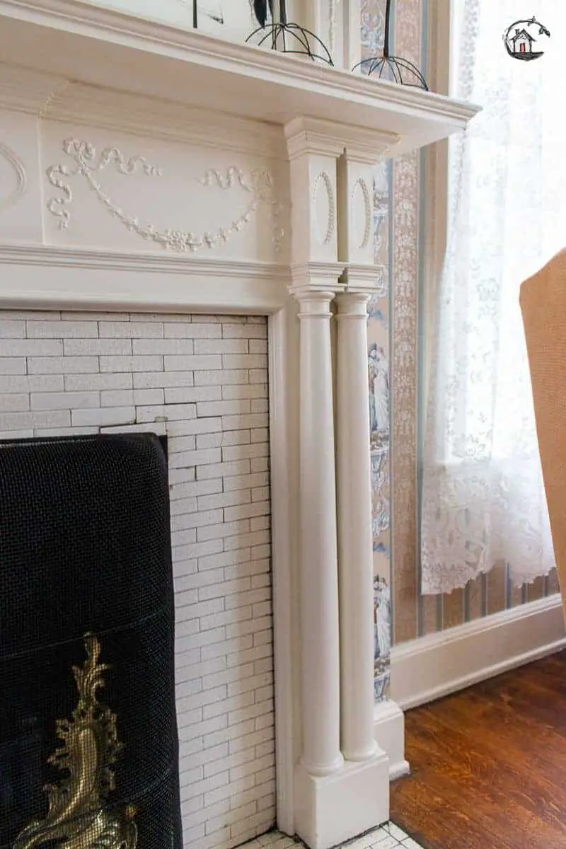 Photo of detailed fireplace surround with white columns and mantel in the Vrooman Mansion. 