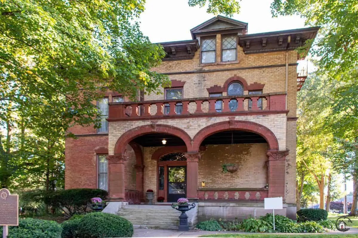 Photo of the front elevation of the Vrooman Mansion, with red brick archways and yellow brick walls. 