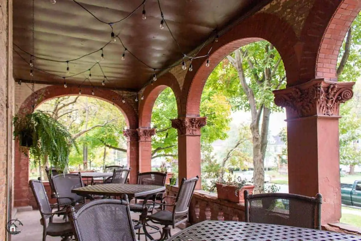 Photo of tables and chairs on the porch of the Vrooman Mansion. 