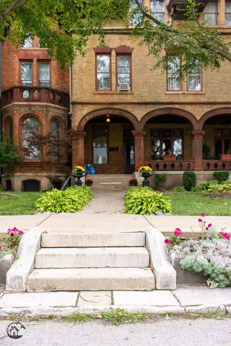 Photo of sidewalk and arched porch covering of the Vrooman Mansion. 