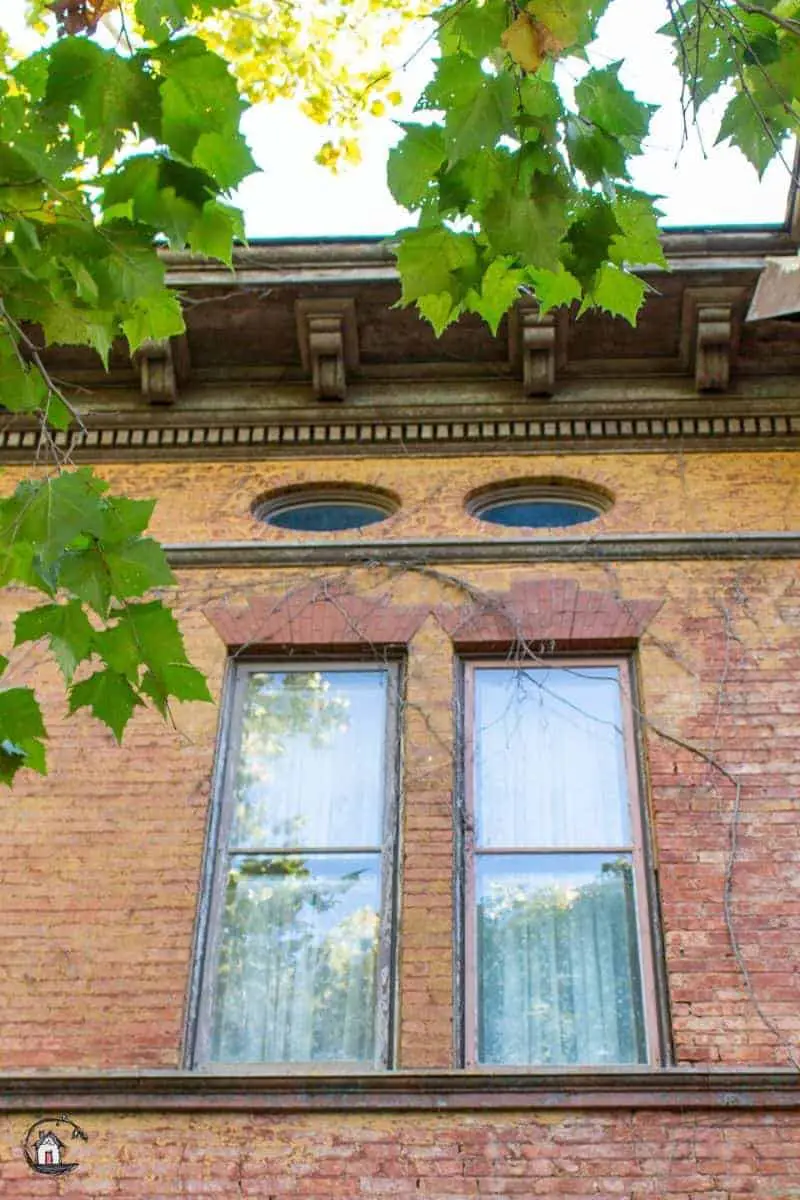 Photo of two small lozenge shaped windows on the Vrooman Mansion. 