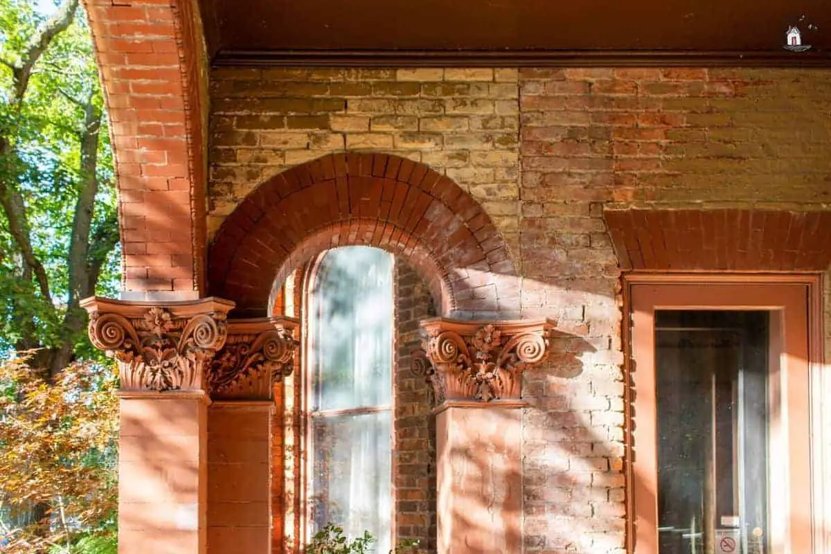 Photo of red brick arch with ornate column capitals at the Vrooman Mansion. 