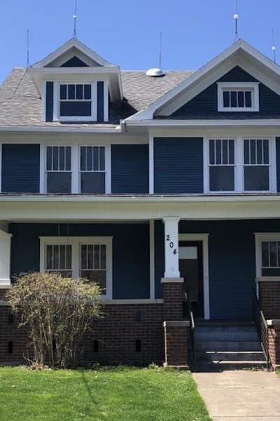 Photo of dark blue American Foursquare house with white trim