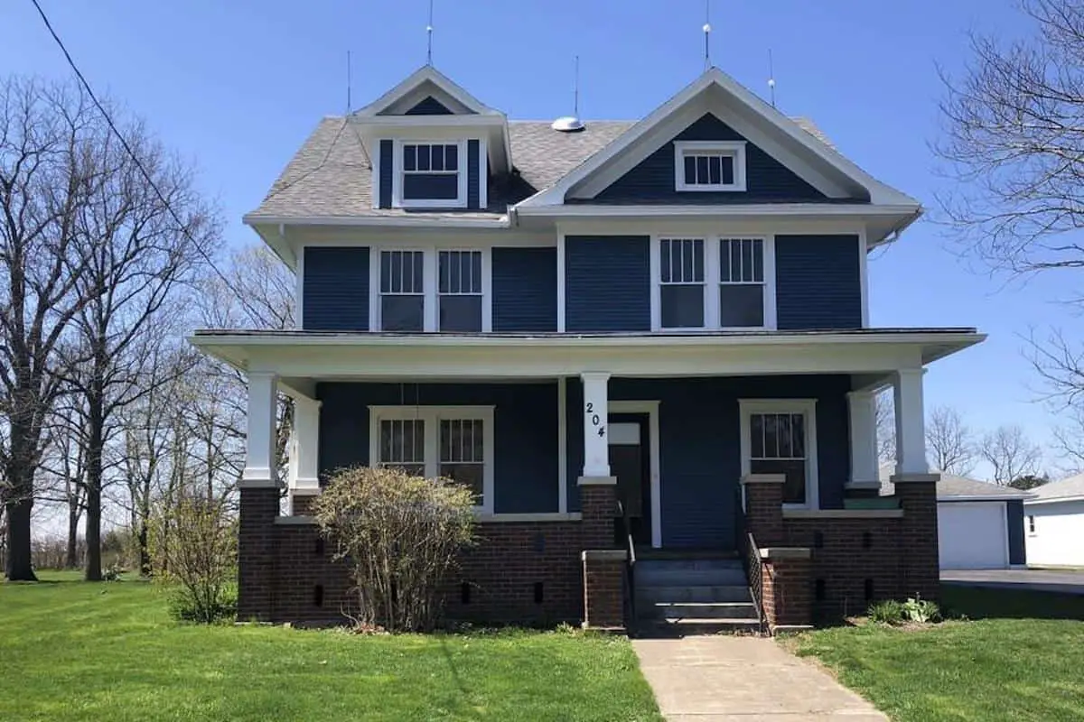 Photo of dark blue American Foursquare house with white trim