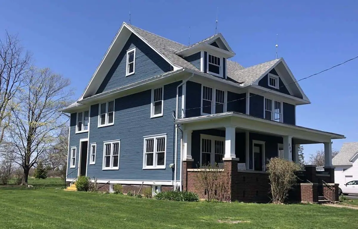 Photo of dark blue American Foursquare house with white trim.