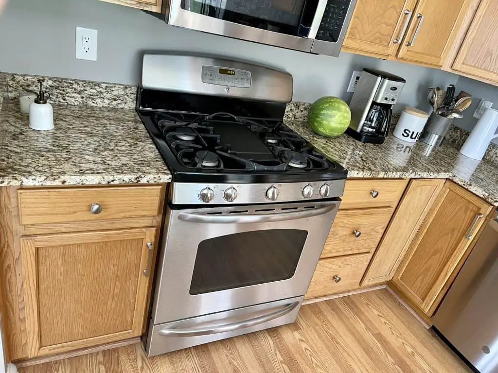 How to Paint Kitchen Cabinets that are Stained 1 kitchen cabinets and a stove before learning how to paint kitchen cabinets that are stained