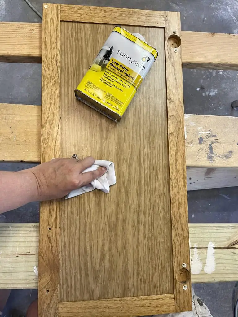 hand wiping mineral spirits on a cabinet door