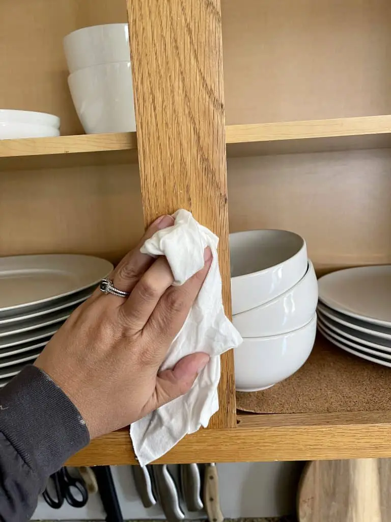 hand with cloth wiping cabinet body