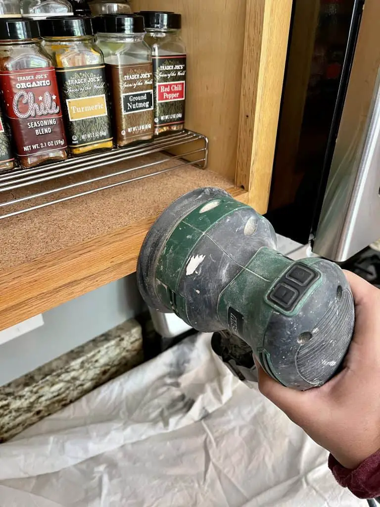 How to Paint Kitchen Cabinets that are Stained 11 sanding cabinets with orbital sander